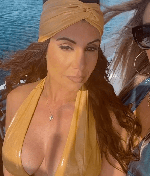 Woman in a yellow swimsuit and headscarf by the water